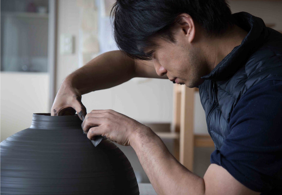 ANZAI APPLIES A FINE LAYER OF BLACK CLAY INFUSED WITH URUSHI–A NATURAL JAPANESE LACQUER DERIVED FROM THE SAP OF THE JAPANESE “VARNISH” TREE (RHUS VERNACIFERA), GIVING EACH PIECE A UNIQUELY DETAILED SURFACE PATTERN TO CONTRAST WITH THE SIMPLE FORMS.